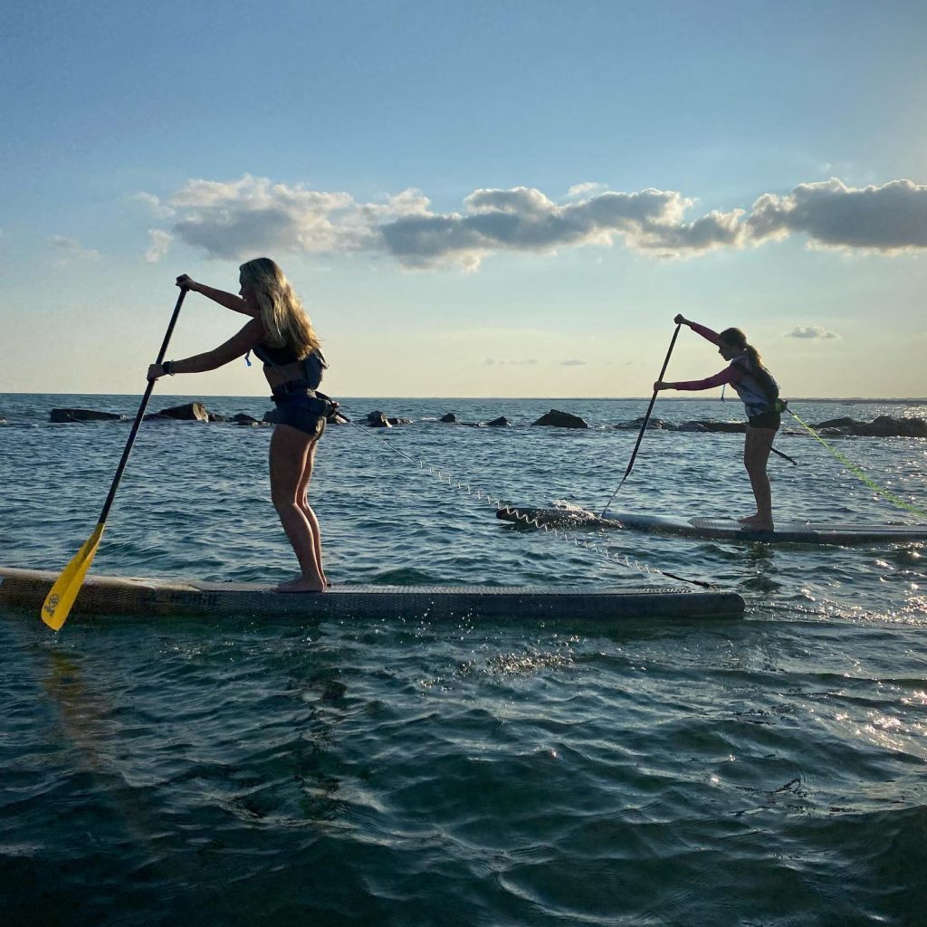 2 people paddle-boarding on ocean