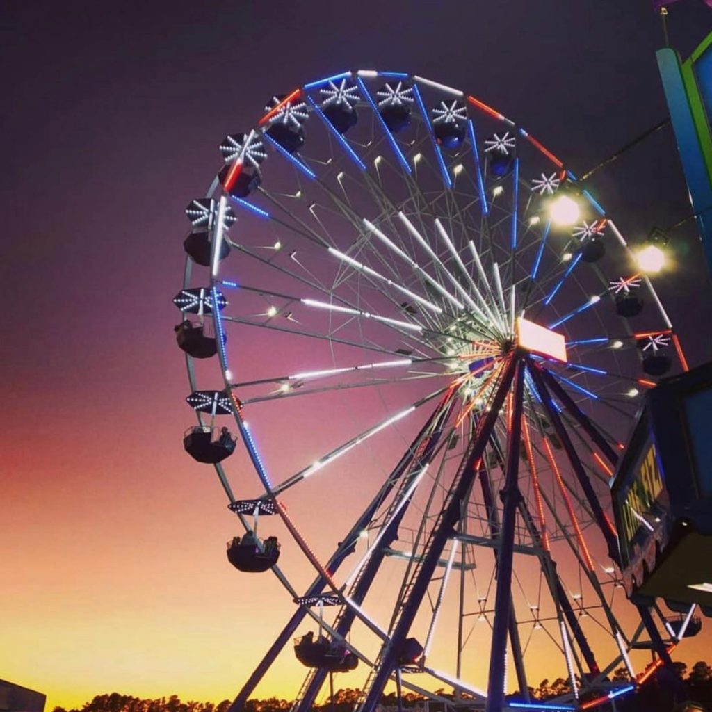 a ferris wheel at sunset at the cape fear fair and expo